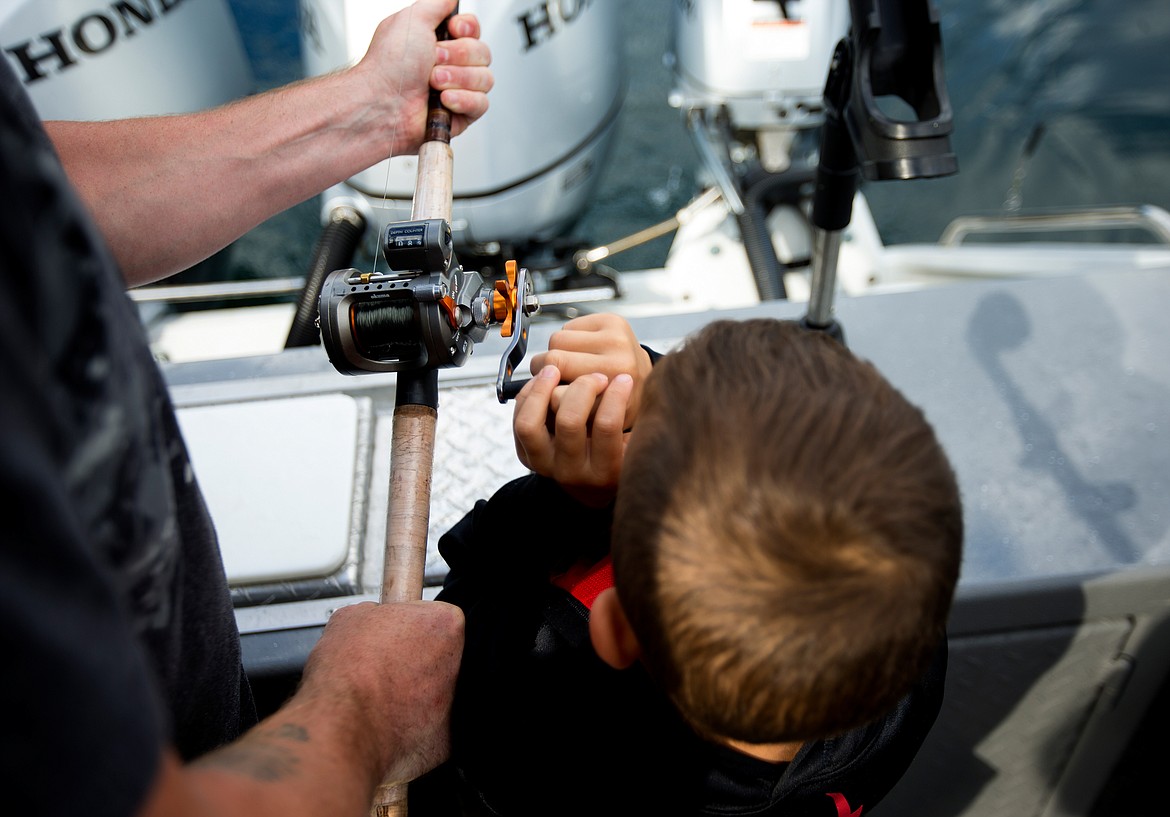 JAKE PARRISH/Hagadone News Network
Collin Rzepa helps his father Jason reel in a kokanee salmon on Friday on Lake Pend Oreille.