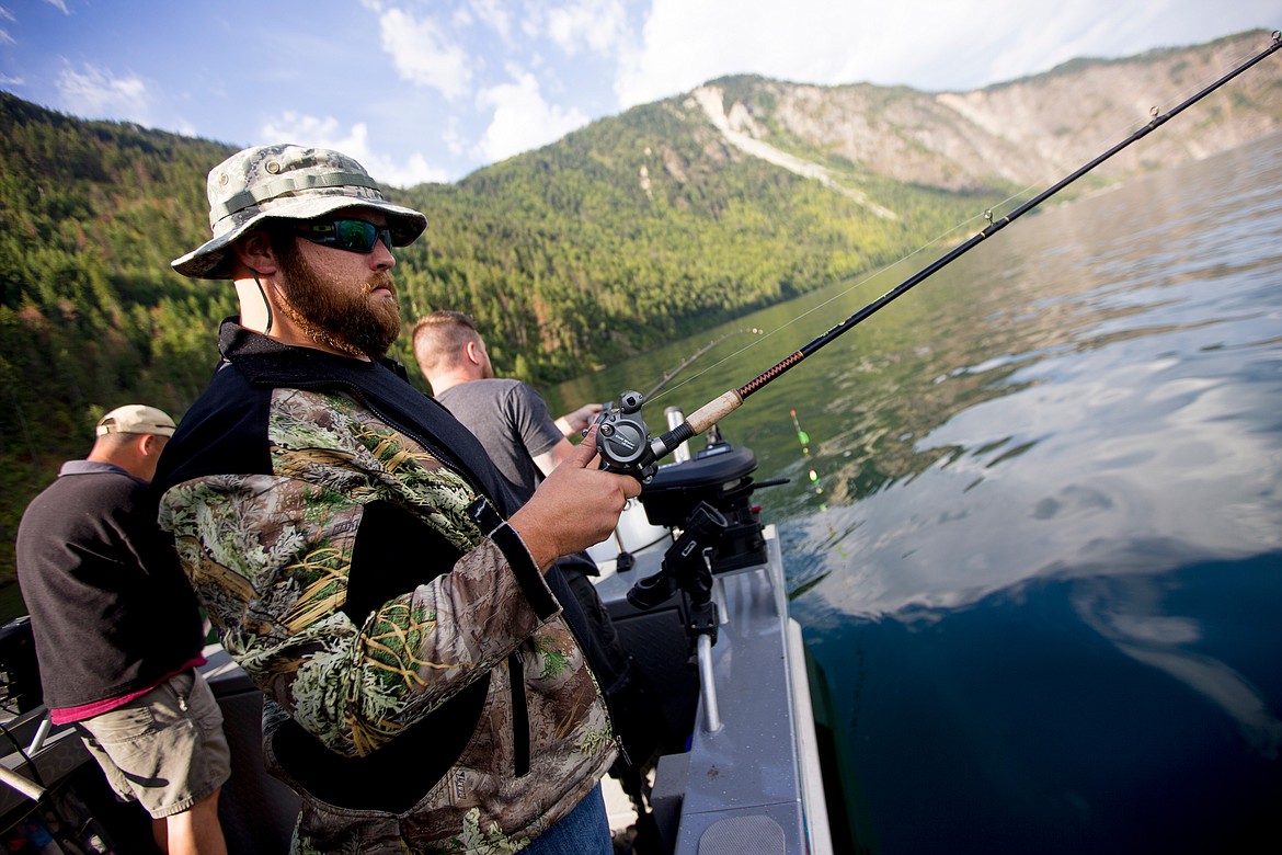 JAKE PARRISH/PressArmy National Guard veteran Ryan Rogers, who served in Iraq, carefully watches his fishing line as he lets it out into Lake Pend Orielle during a Boats for Heroes fishing trip on Friday.