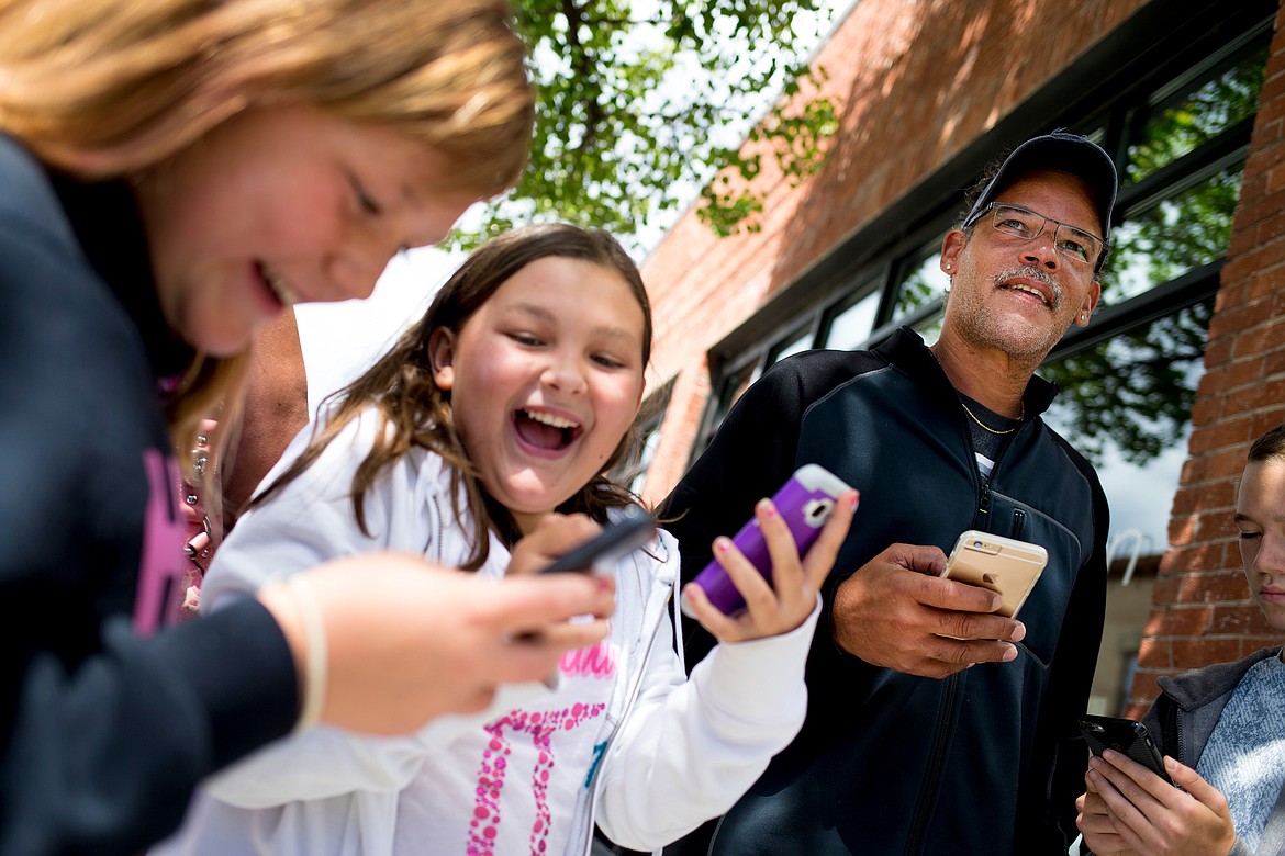 JAKE PARRISH/Press

Jillian Smith, left, and Kiahna Soura, both 10, laugh as they try to catch Pokemon in the hit mobile-phone game Pokemon Go on Monday with Chuck Holt, right, on the corner of Fifth Street and Sherman Avenue in Coeur d&#146;Alene.