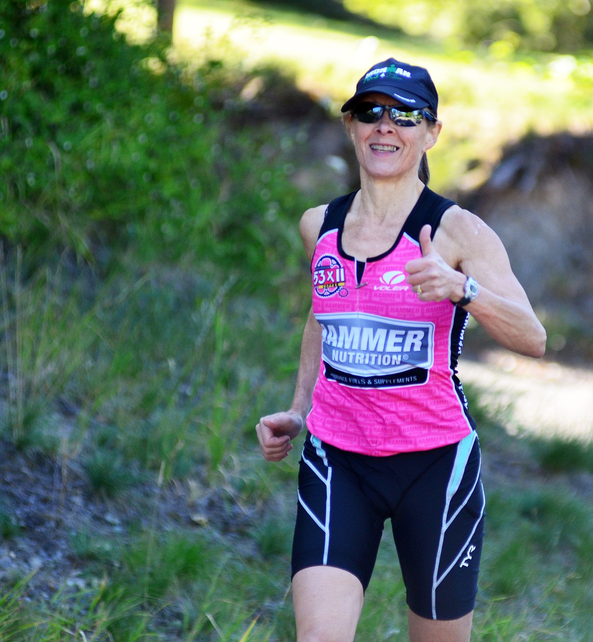 Heidi Desch / Whitefish Pilot
Left, a competitor gives a thumbs up during the start of the 5-kilometer run Sunday during the Whitefish Lake Triathlon. Right, a competitor rides along Wisconsin Avenue during the biking portion of the Whitefish Lake Triathlon Sunday.