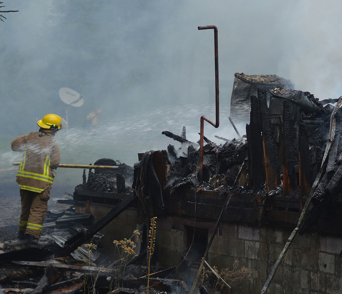 A firefighter works on a blaze that destroyed a home in Essex Monday afternoon.