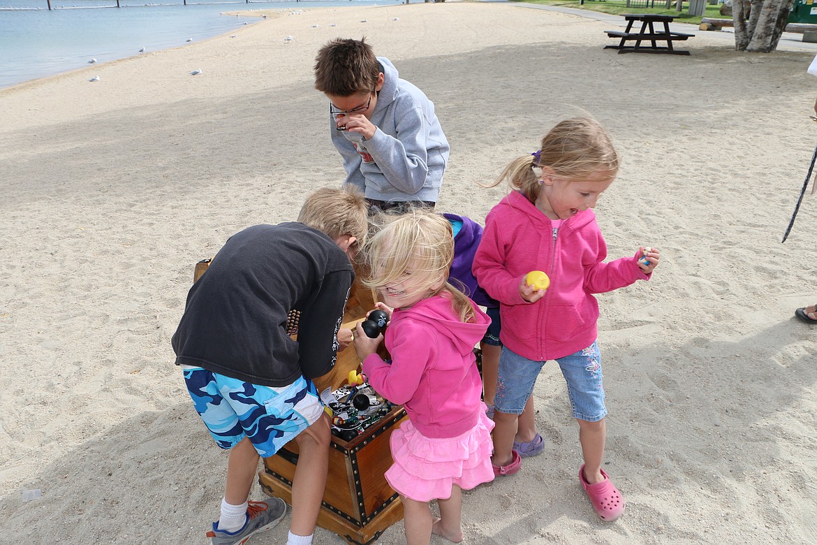 &#151; Photo by MARY MALONE
Abi Muhly, 2, of Coeur d'Alene looks up as she found a treasure in the pirate treasure chest belonging to Captain Dan Mimmack of Sandpoint. Also &quot;plundering&quot; are her siblings, 9-year-old Nathaniel, left, 11-year-old David, top center, and twins Hannah and Rebecca, 4, although Hannah is unseen behind her twin as she reaches down to find just the right treasure.