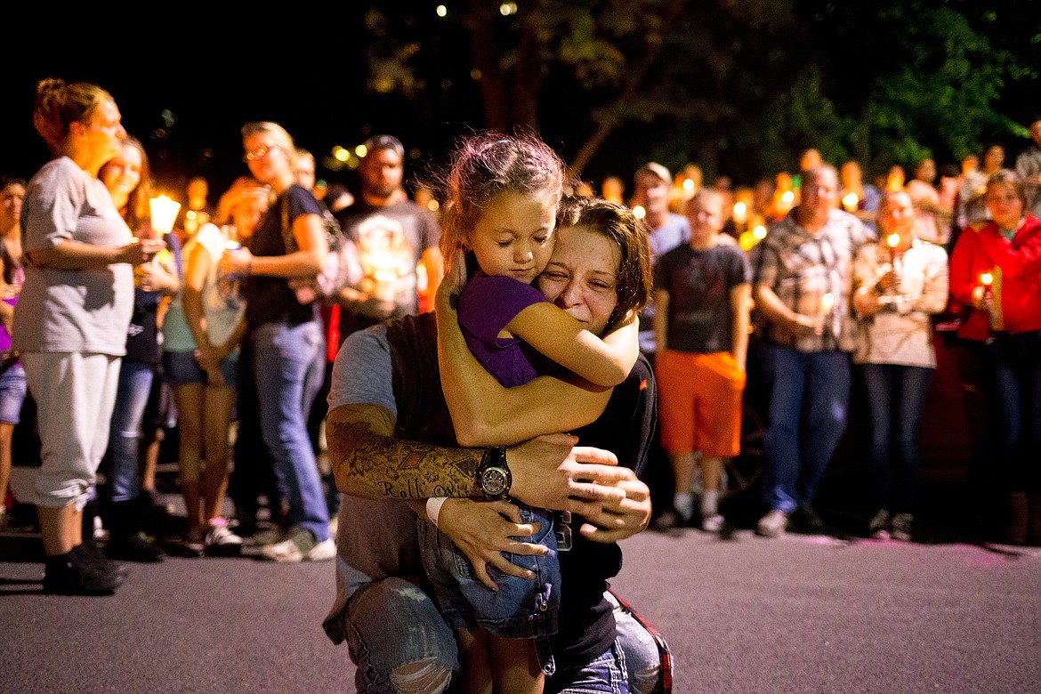 JAKE PARRISH/PressDacia Cheyney and Antonio Wilburn, parents of Maliki Wilburn, hug Maliki's cousin Leticia Hewitt, 6, during a candlelight vigil for Maliki on Monday evening at Crowley Park in Spokane.