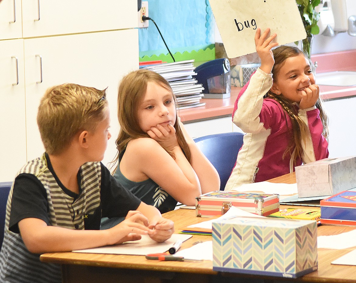 Margo Alexander holds up a sign showing her nickname Wednesday in Mrs. Akey&#146;s third-grade class. Also pictured are Henry Barbieri and Scarlet Burke.