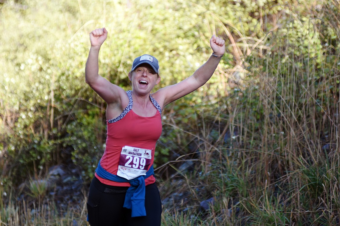 Kate Harrison of Missoula cheers as she runs along East Lakeshore Drive Sunday during the half marathon for the Two Bear Marathon. Heidi Desch / Whitefish Pilot