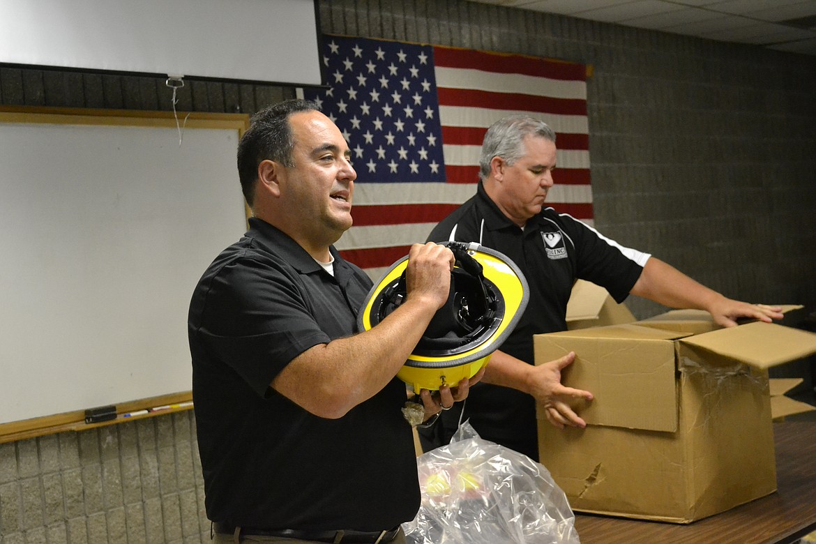 &#151;Photo by SARAH JENKINS
Phenix Fire Helmets representative, Angel Sanchez Jr. demonstrates how the new helmets differ from traditional helmets.