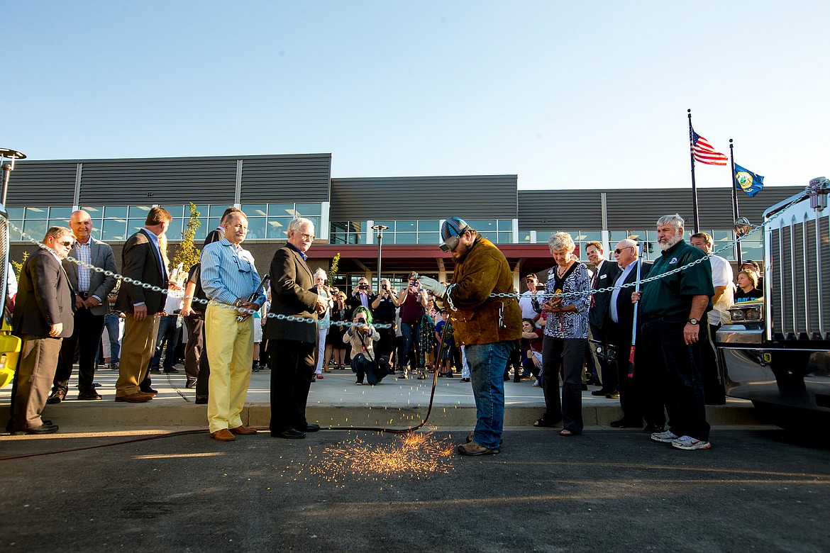 JAKE PARRISH/PressNorth Idaho College welding student Randall Bramblee cuts the ceremonial chain on Wednesday to mark the grand opening of the college's Parker Technical Education Center in Rathdrum.