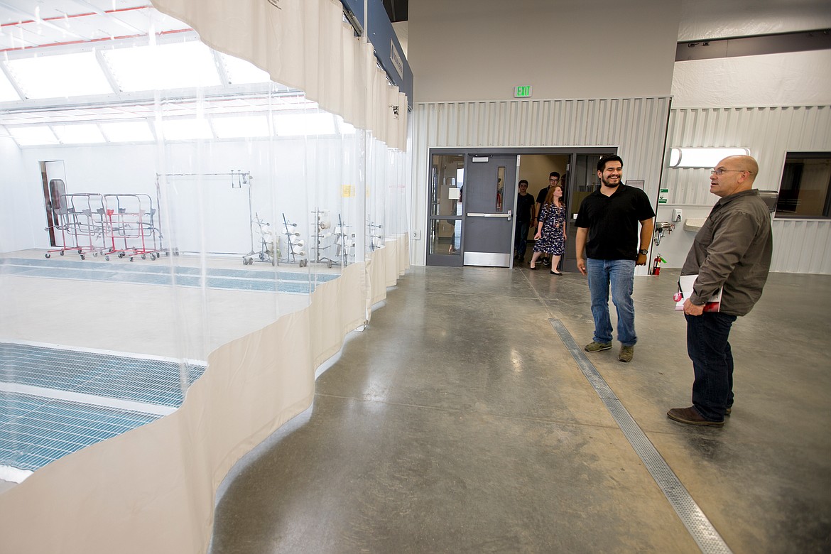 JAKE PARRISH/PressFirst-year collision repair student Jacob Jasso, left, talks to Vince Barranco about the center's modern car painting facility on Wednesday.