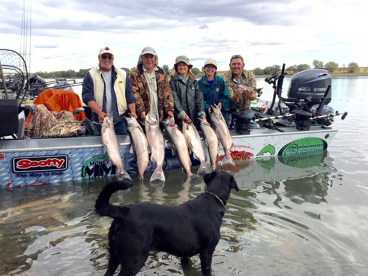 Ted Escobar/The Sun Tribune
ABOVE For Kevin Long, far right, and his father Richard, far left, the work is most enjoyable because of company they keep.

RIGHT When fishermen ask how big, Kevin just pulls out this photo.