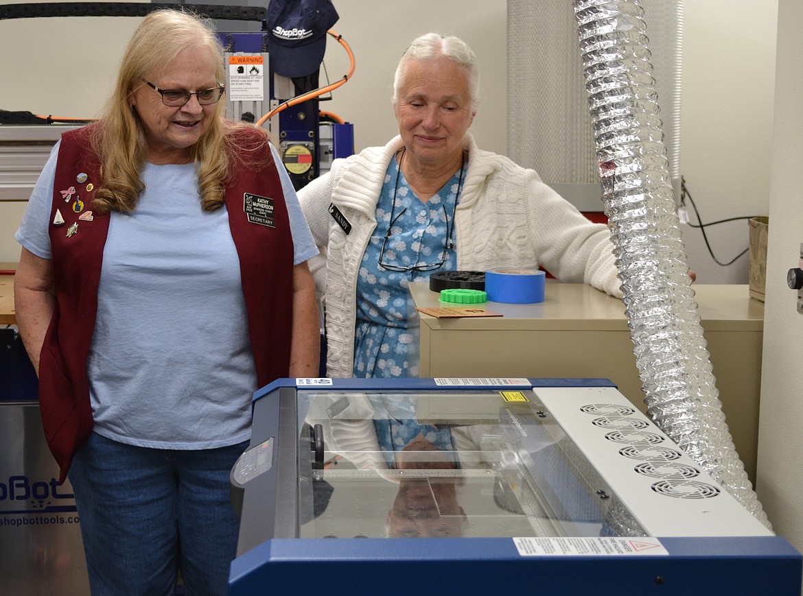 &#151;Photo by: SARAH JENKINS
Eagles member Tracey McPherson and Sandy Ashworth watch the latest machine in the FAB Lab.