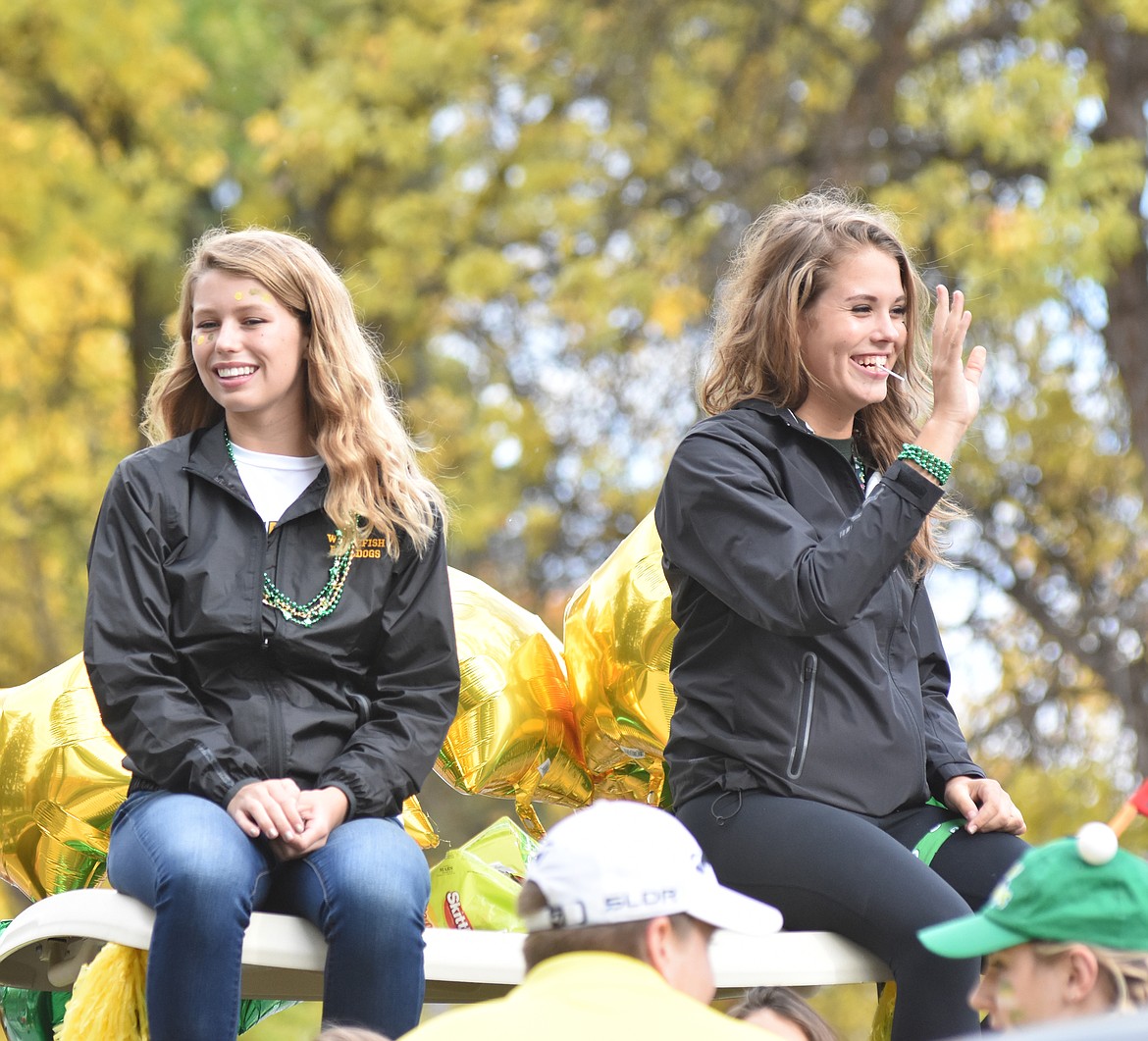 Two members of the Lady Bulldogs golf team ride Friday in the Whitefish High School Homecoming parade.