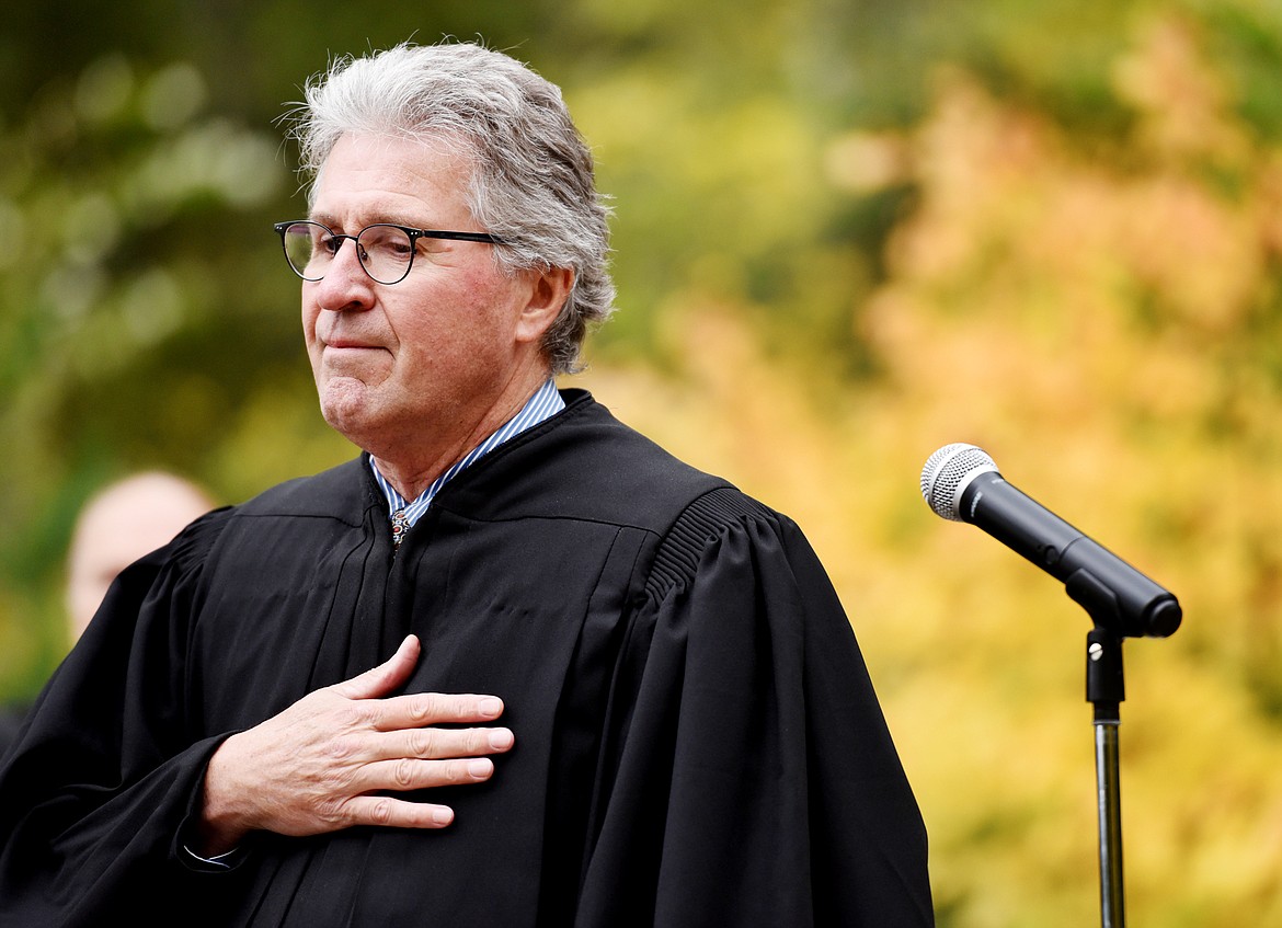 Judge Dana L. Christensen stands with hand over heart for the National Anthem preformed by Rob Quist at the&#160;Naturalization Ceremony in Glaicer National Park on Wednesday, September 21. In his remarks Christensen related his own families&#160;immigrant experiences and his Danish heritage.(Brenda Ahearn/Daily Inter Lake)