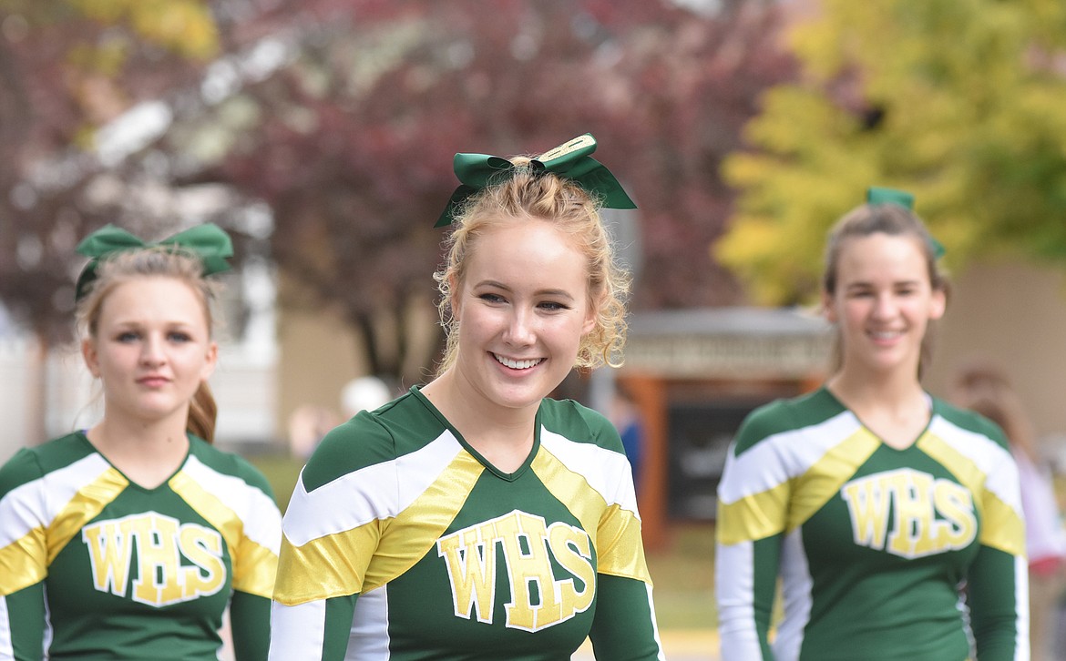 Cheerleaders ride scooters Friday through town during the Whitefish High School homecoming parade.