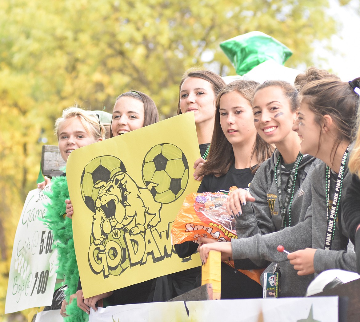 The girls soccer team throws out candy Friday during the Whitefish High School Homecoming parade.