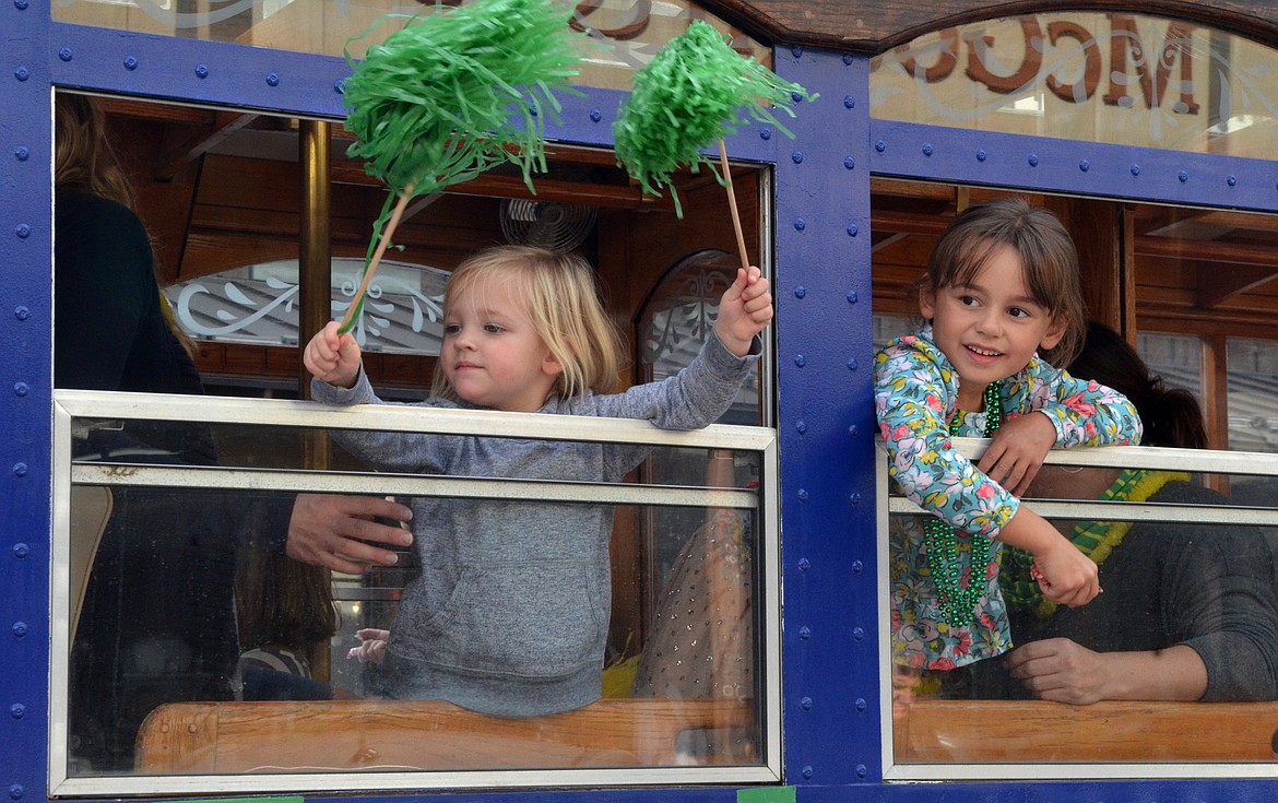 Two youngsters wave out of a trolley for the PTA Friday during the Whitefish High School homecoming parade.