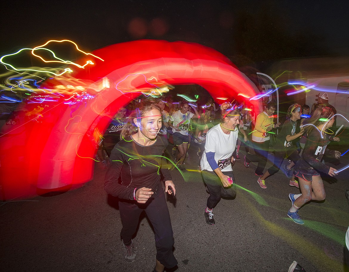 Racers take off at the statrt of the Glacier Glow Run in Columbia Falls Friday night.