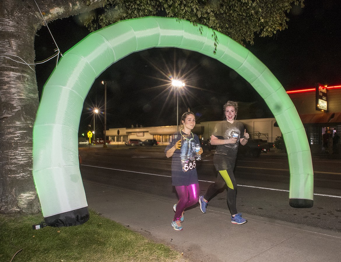 Runners sprint down Nucleus Avenue in the Glacier Glow Run Friday.