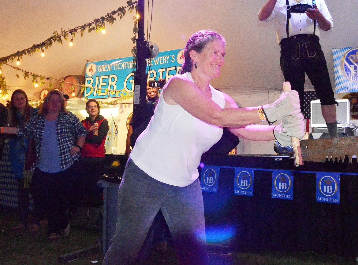 Caren Fricke competes in the women&#146;s log sawing competition Thursday evening at the Great Northwest Oktoberfest at Depot Park.