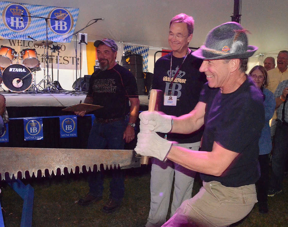 Glenn DeHekker of Whitefish pulls the saw during the men&#146;s log sawing competition Thursday evening at the Great Northwest Oktoberfest at Depot Park.