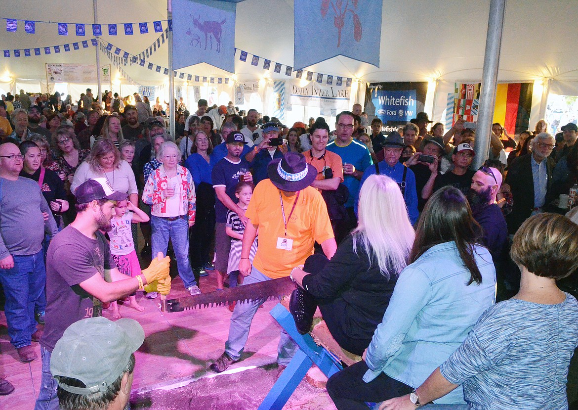 The crowd gathers around to watch the men&#146;s log sawing competition Thursday evening at the Great Northwest Oktoberfest at Depot Park.