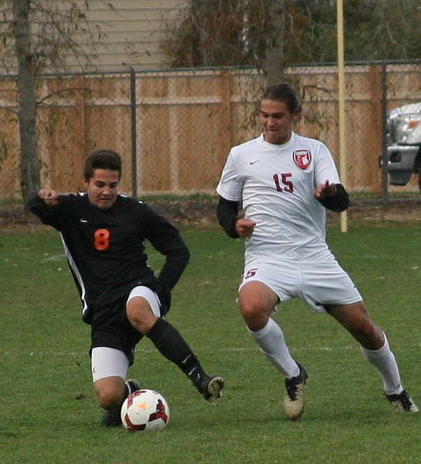 &#151;Photo by ERIC PLUMMER
Luke Koch, right, tries to gain possession in action against the Trojans at Pine St. Field.