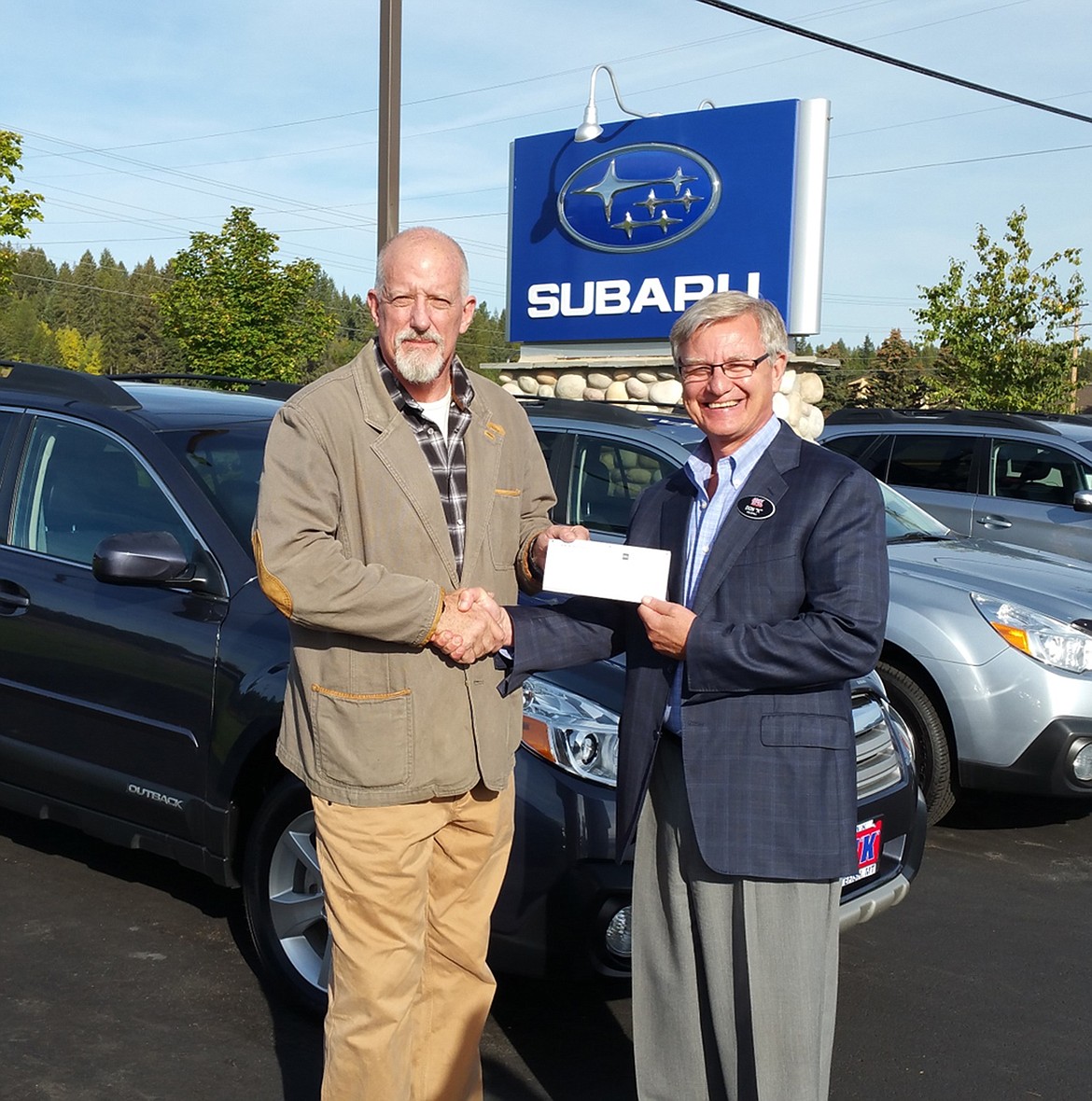 George Bristol accepts a check from Don Kaltschmidt.