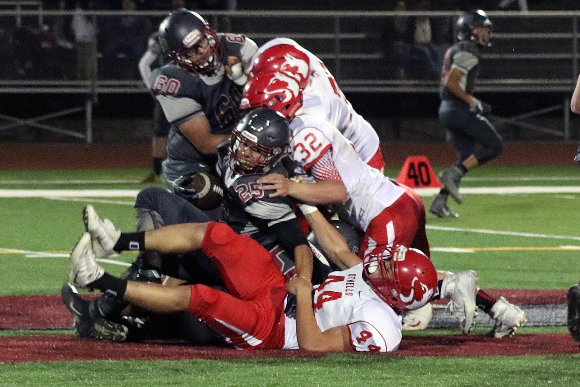 Bob Barrett Photo - Armando Barragan (52), Trevor Hilmes (32) and Isaiah Perez (44) stop Grandview's Christian Gomez. The Huskie defense has been key to their victories.