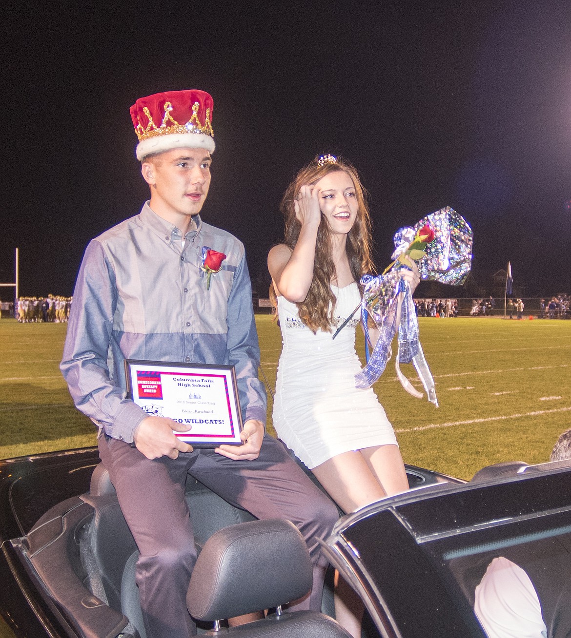 King Louis Marchand and queen Keavyn Baker ride off the field after being crowned at homecoming.