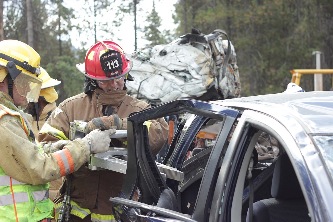 &#151;Courtesy photo
Wally Nyberg, Hall Mountain Fire Department and Kevin Ingram of North Bench Fire Department, pry open the door to a totaled vehicle, during Extrication Operations training.