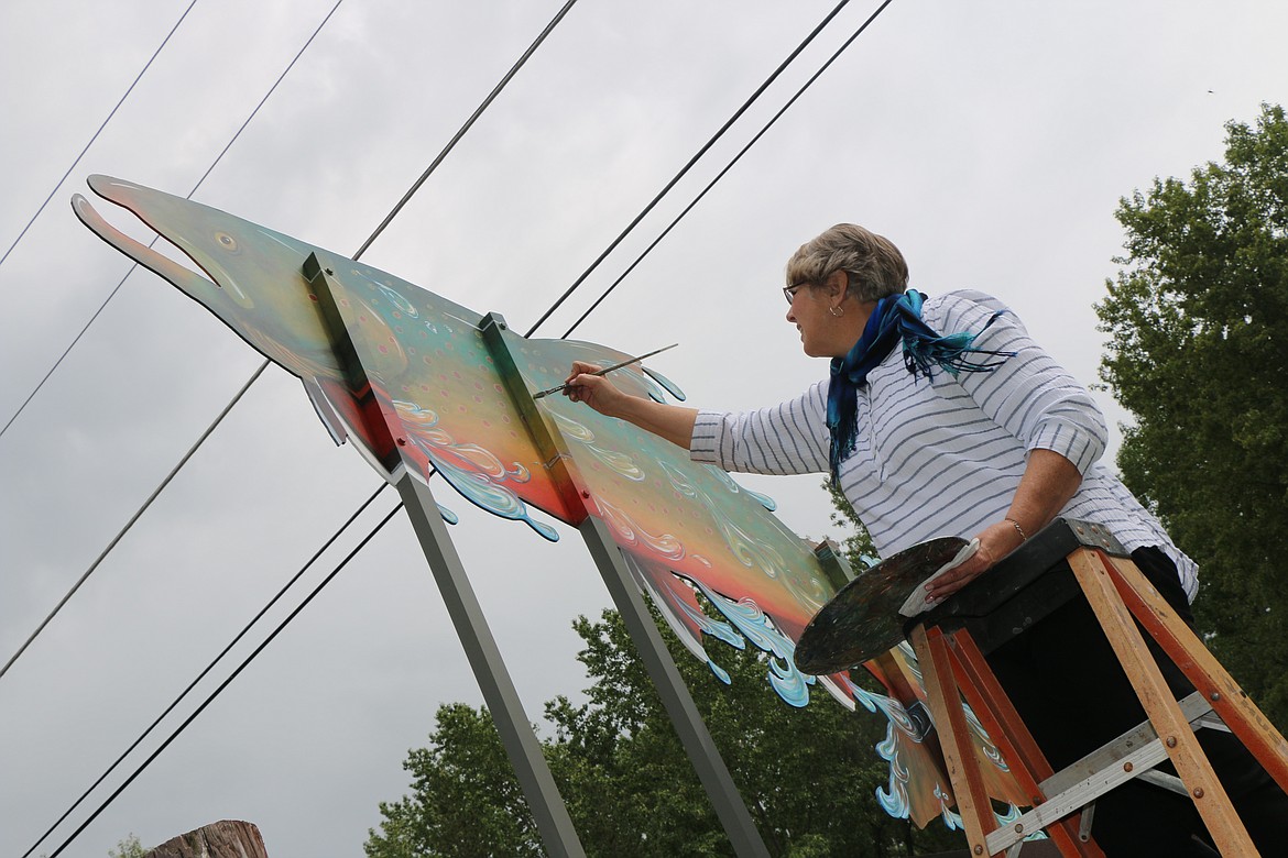 &#151;Photo by CAROLINE LOBSINGER
Maria Larson puts the finishing touches on the Waterlife Discovery Center&#146;s new sign.