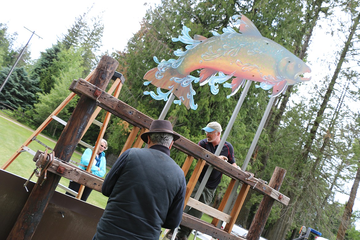 &#151;Photo by CAROLINE LOBSINGER
Maria Larson watches as her husband, Lars Larson, and Idaho Fish &amp; Game conservation officer Tom Whalen get ready to install Waterlife Discovery Center's new sign.