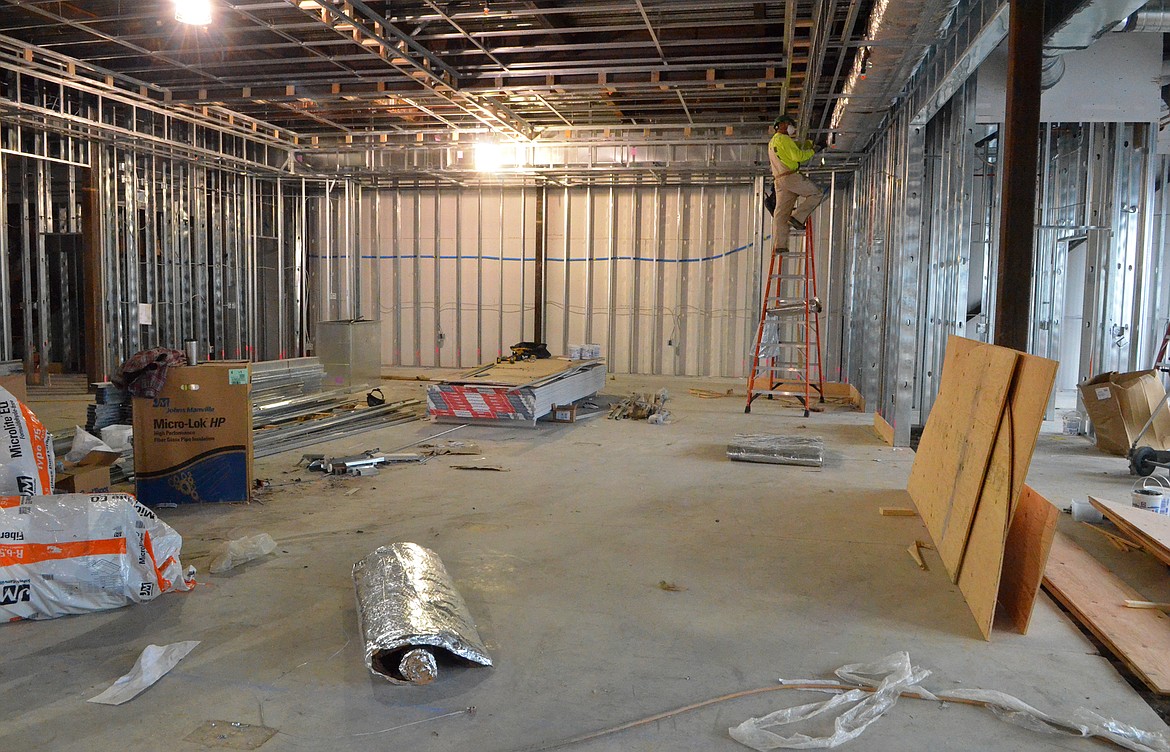 A construction worker stands on a ladder last week inside the room that will become City Council Chambers on the second floor of the new City Hall building.