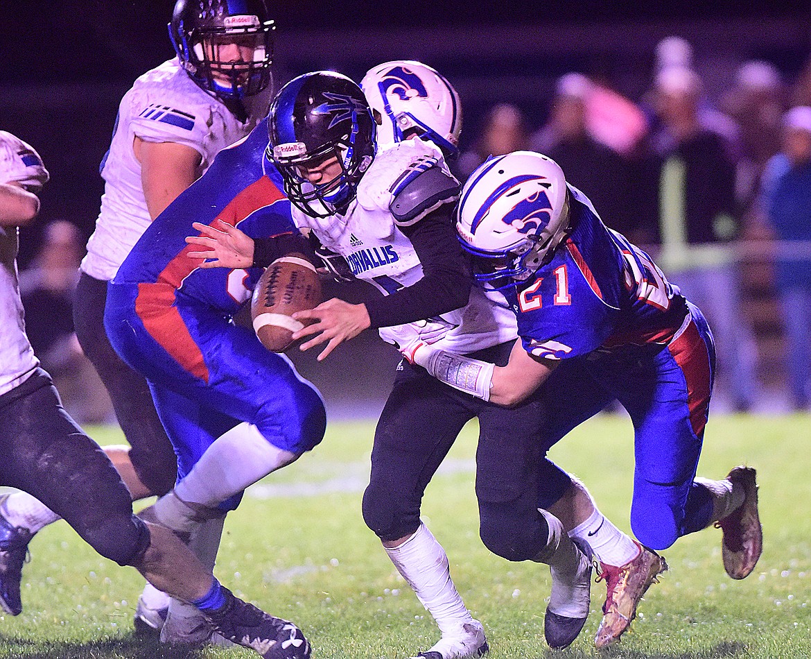 Austyn McCubbins, left, and Bryce Fagerland force a Corvallis fumble in the second half.