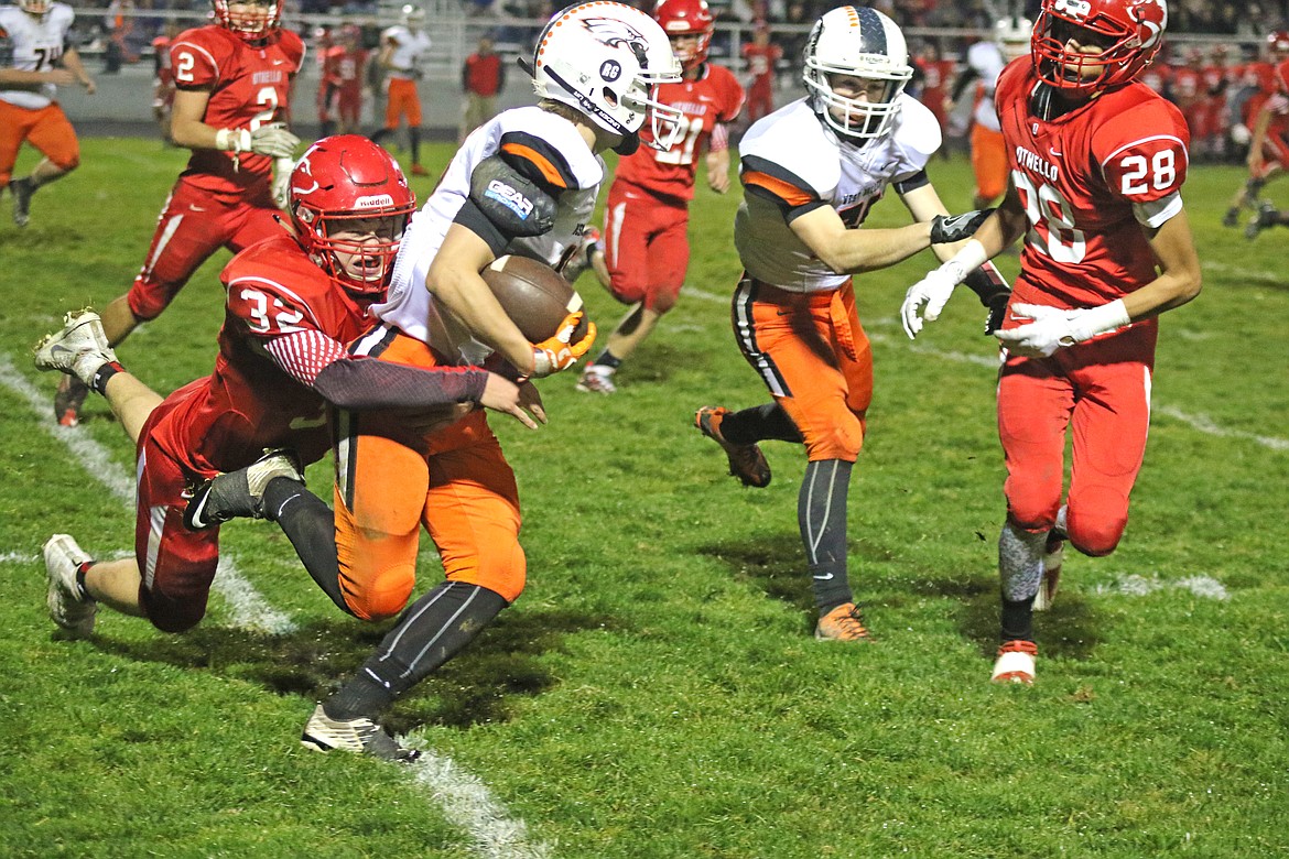 Bob Barrett Photo - Othello's Trevor Hilmes makes a tackle against West Valley of Spokane in a cross-over play-off game that end the Huskies football season.