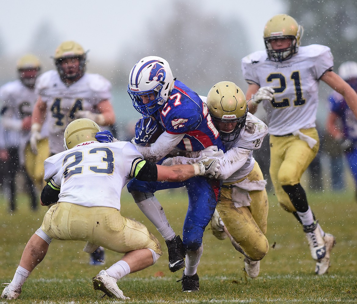 Wildcat receiver Trey Gates fights for yards against two Dillon defenders Saturday in Columbia Falls in the state A championship game. (Chris Peterson photo)