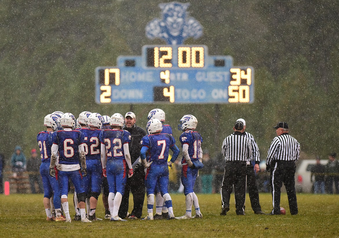 Coach Jaxon Schweikert talks to the team at the start of the fourth quarter.