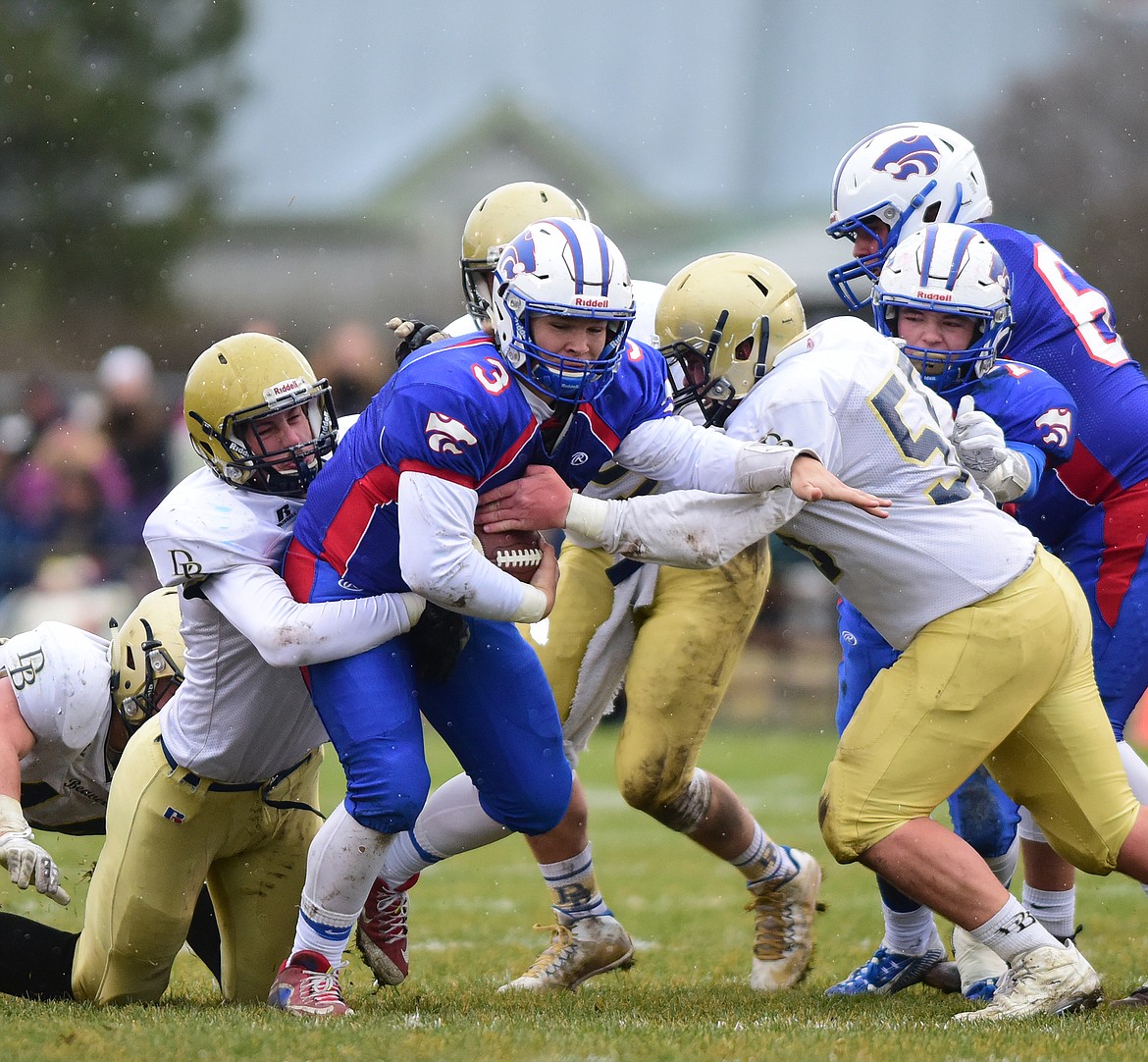 Columbia Falls quarterback Dakota Bridwell (center) fights for yards against Dillon in the first half of the state A championsips in Columbia Falls Saturday.