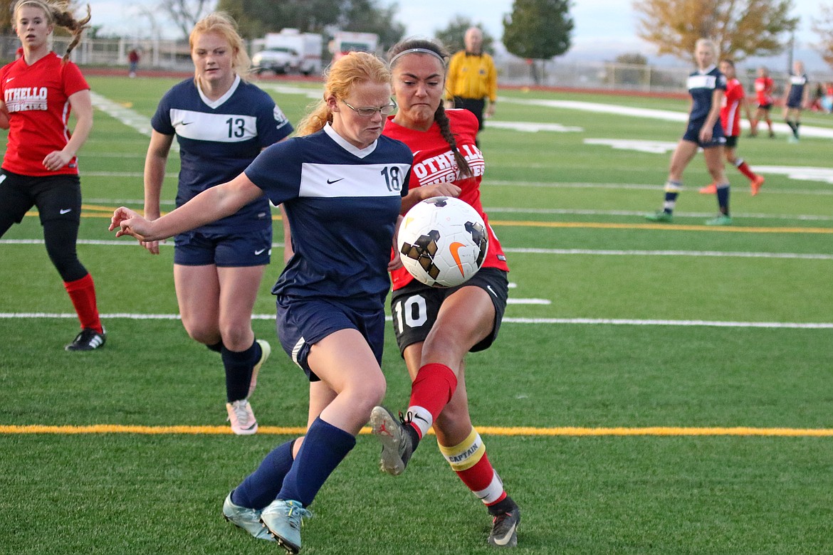 Bob Barrett Photo - Othello's Nikki Velazquez boots the ball toward the Bulldog goal despite the defense of Ellensburg's Tamzen Shissler.