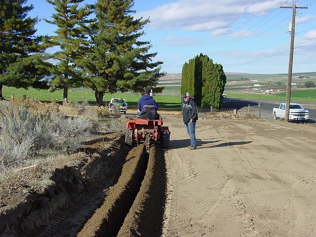 Ted Escobar/The Sun Tribune - Ryan Christensen supervises as Luis Gomez opens a trench for an underground sprinkler system for expansion of the Royal Memorial Gardens Cemetery.