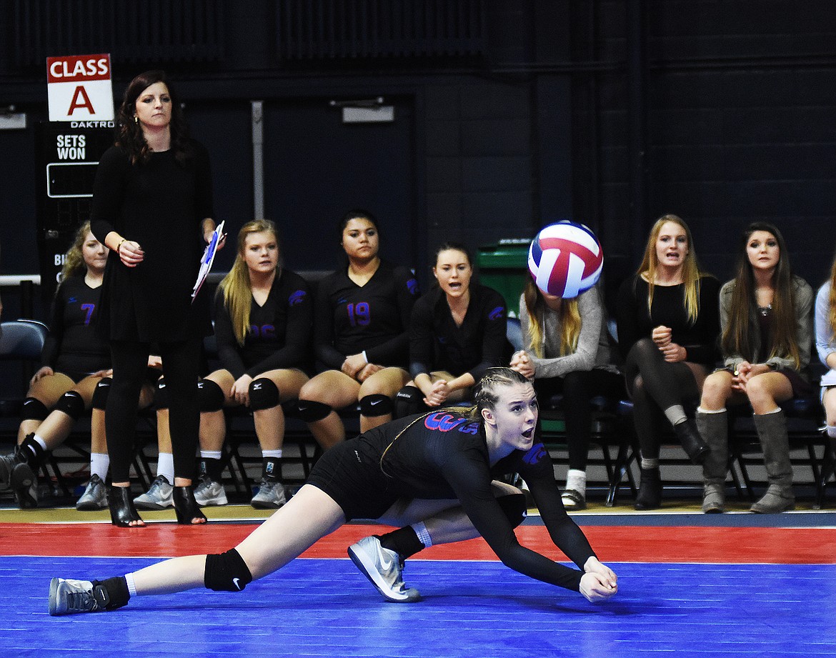 Kiara Burlage with a dig against Central while the bench looks on.