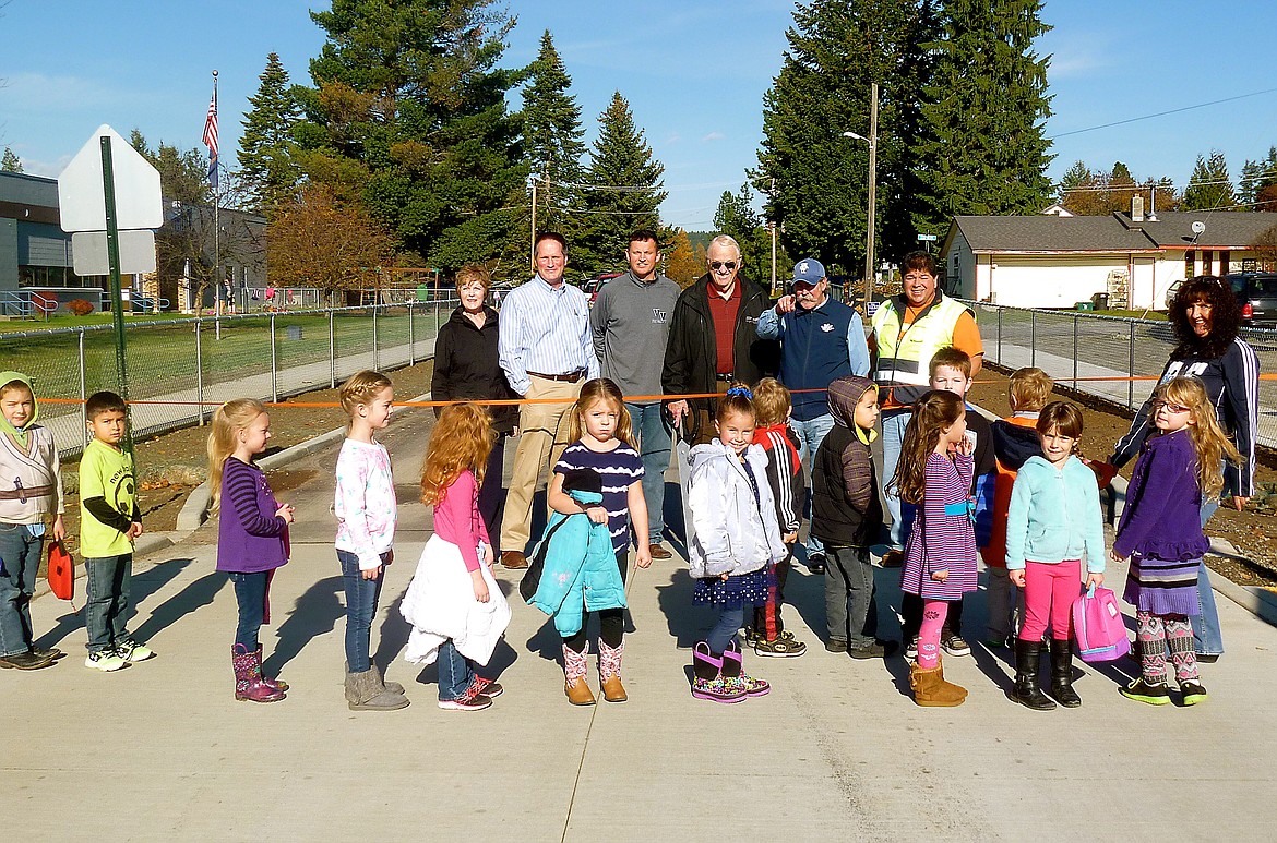 Students break in the new crosswalk in front of Valley View Elementary along with faculty and city officials last Thursday during the ribbon cutting ceremony. From left, Kris Larson, clerk/treasurer; David Sims, mayor; Nathan Williams, Valley View principal; Ron Smith, councilman; Gary Pflueger, superintendent; John Youngwirth, street superintendent; Debbie Pauls, teacher. The ribbon cutting ceremony was held Nov. 3, marking the completion of the school&#146;s new crosswalk, included in the Augusta Street project. The project was funded primarily with a $375,000 Community Choices Grant from the Idaho Transportation Department. One of the main goals of the project was to increase pedestrian safety. The project includes an upgraded highway pedestrian crossing, a sidewalk from the highway to Valley View Elementary School, improved drainage, an asphalt overlay of the street and the pedestrian crossing in front of Valley View.

&#151;Courtesy photo