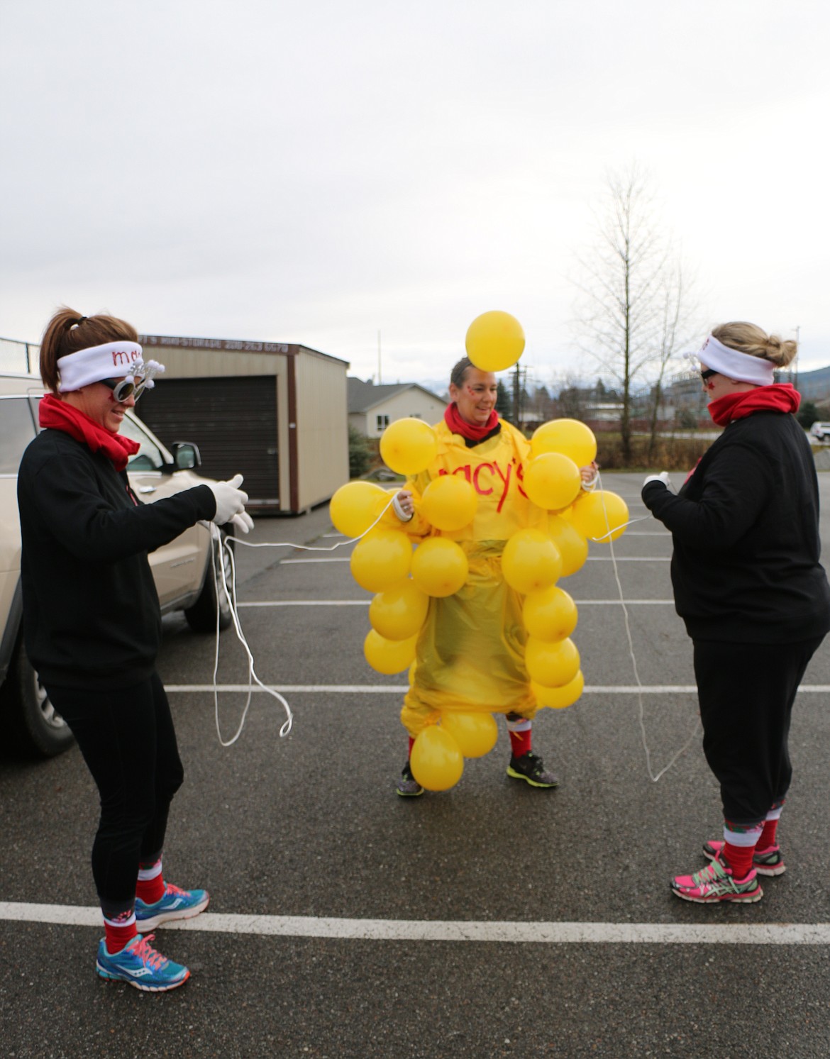 &#151;Photo by CAROLINE LOBSINGER
Sisters Vanessa, Emma and Amanda Keverkamp put the finishing touches on their Macy's Thanksgiving Day Parade-inspired costume at the start of Thursday's Turkey Trot fun run.