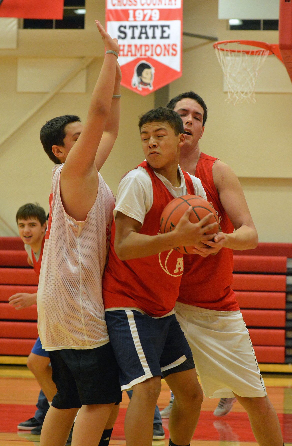 ARLEE HIGH School basketball players Cody Tanner and Rory Bird trap Darshan Bolen during the Friday morning practice at Arlee High School. (Jason Blasco/Lake County Leader)