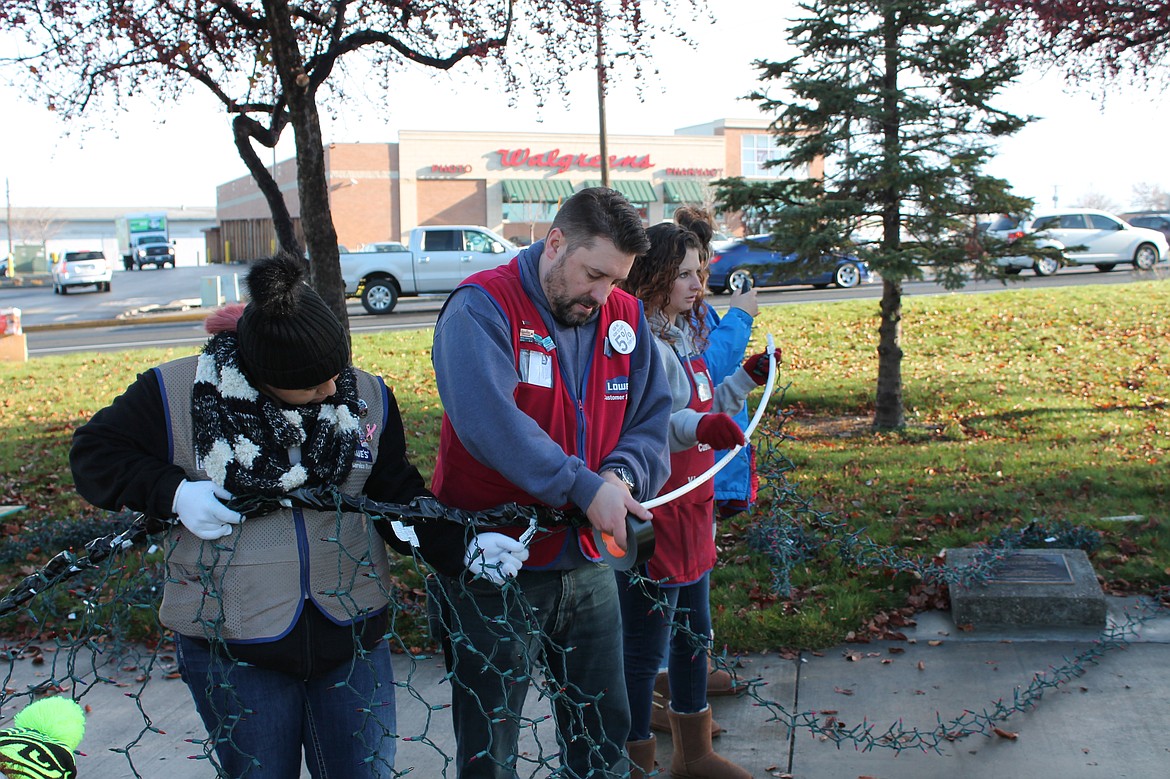 Charles H. Featherstone/Columbia Basin Herald
Lowe&#146;s employees Ashley Castro, Jeremy Winn, and Charlie Wood tape Christmas tree lights as they prepare their first attempt to deck the tree.