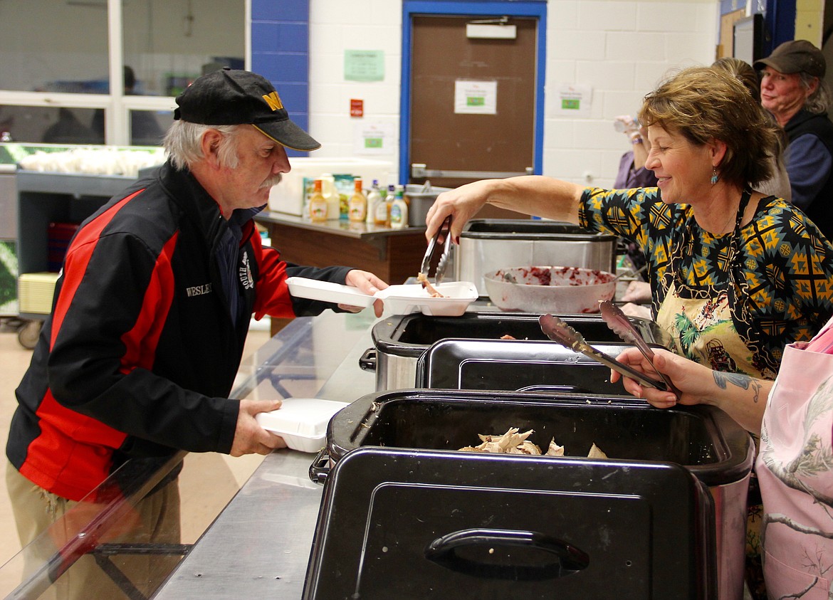 &#151;Photo by DAC COLLINS
Volunteer Deana Merrifield serves ham at the community Thanksgiving dinner that took place on Sunday, Nov. 20 in the Boundary County Middle School Cafeteria. Volunteers served well over 500 people at the event, which was hosted by the Ministerial Assocation. Approximately 50 turkeys and 30 hams were donated for the event.