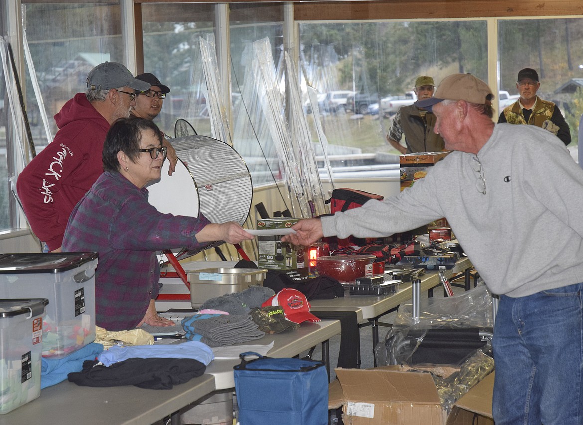 ANGLER Bob Christensen receives a prize from Mack Days organizer Cindy Bras during the derby&#146;s award ceremony on Sunday.