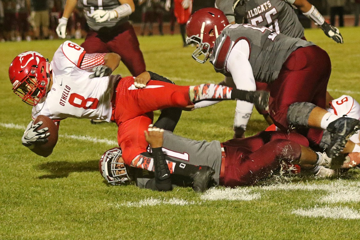 Bob Barrett Photo - Othello's Trevor Hilmes (32) makes a tackle against West Valley as cornerback Jose Gomez (28) provides assistance.