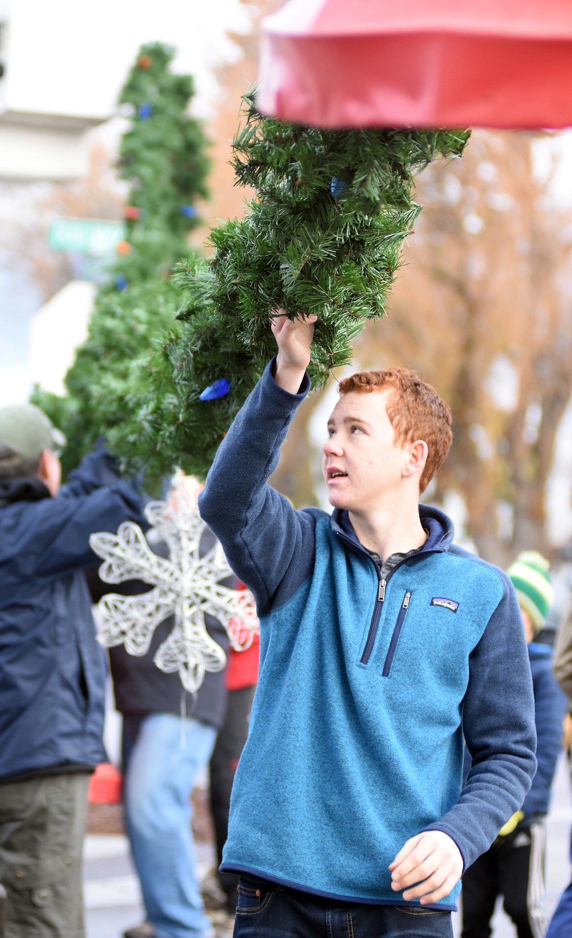 Volunteers descended on downtown Whitefish Sunday morning to hang up the winter decorations.