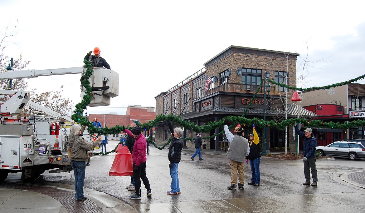 Volunteers descended on downtown Whitefish Sunday morning to hang up the winter decorations.