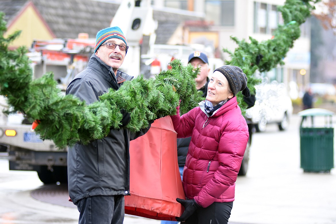 Volunteers descended on downtown Whitefish Sunday morning to hang up the winter decorations.